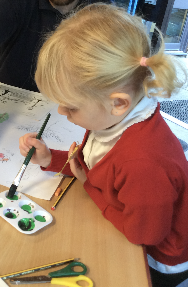A girl holding a picture of a lino print of a sea bird. 